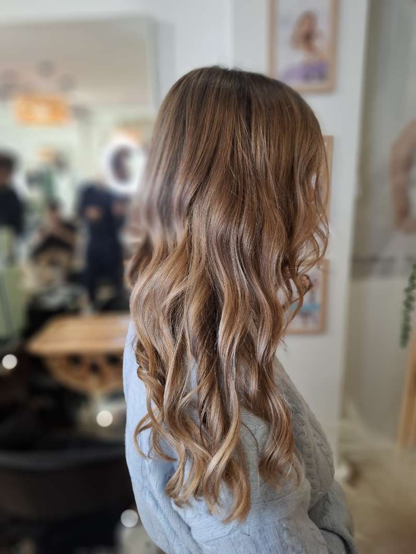 Balayage caramel ondulations naturelles vue arrière au salon XOXO COIFFURE Paris 6ème